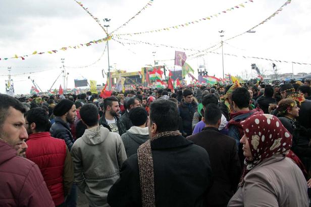 Eine große Menschenmenge versammelt sich unter bunten Flaggen und Girlanden.