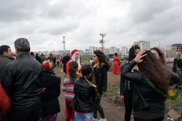 Eine Gruppe von Menschen versammelt sich vor einer Stadtkulisse.