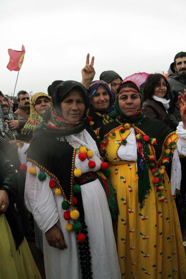 Frauen in traditioneller kurdischer Kleidung stehen in einer Menschenmenge.