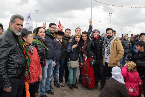 Eine Gruppe von Menschen posiert für ein Foto, einige zeigen das Victory-Zeichen.