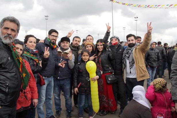 Eine Gruppe von Menschen posiert mit Friedenszeichen und einem gelben Ballon für ein Foto.