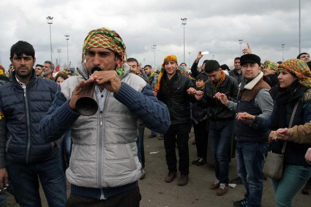 Eine Gruppe von Menschen tanzt und musiziert auf einer Straße.