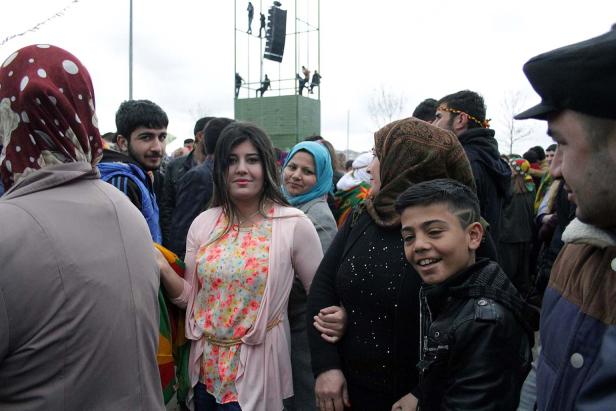 Eine Gruppe von Menschen versammelt sich vor einem Denkmal im Freien.