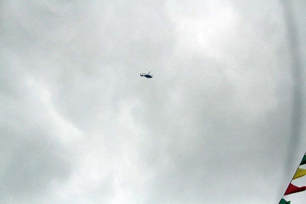 Ein Hubschrauber fliegt vor einem bewölkten Himmel.