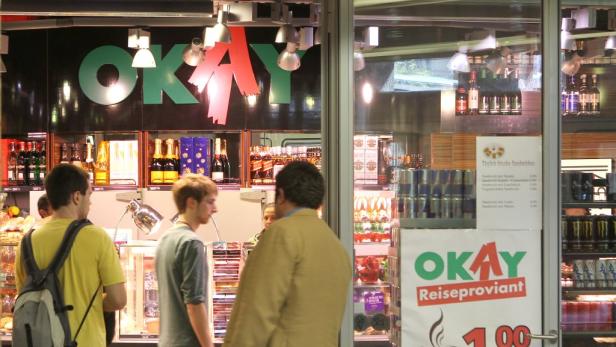 Kunden betreten ein „Okay“-Reiseproviant-Geschäft.