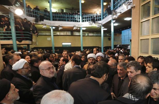 Eine große Menschenmenge versammelt sich in einem Innenraum mit einer Galerie.