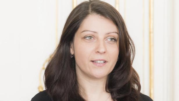 Porträt einer Frau mit langen, dunklen Haaren und hellen Augen.