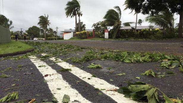 Eine Straße ist mit Blättern und Ästen nach einem Sturm bedeckt.