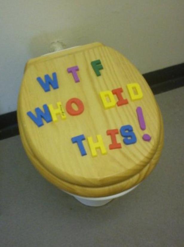 Auf einem Toilettendeckel steht mit bunten Buchstaben „WTF WHO DID THIS!“.