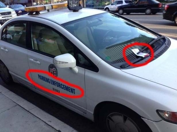 Ein Parküberwachungsfahrzeug mit einem Strafzettel unter dem Scheibenwischer.