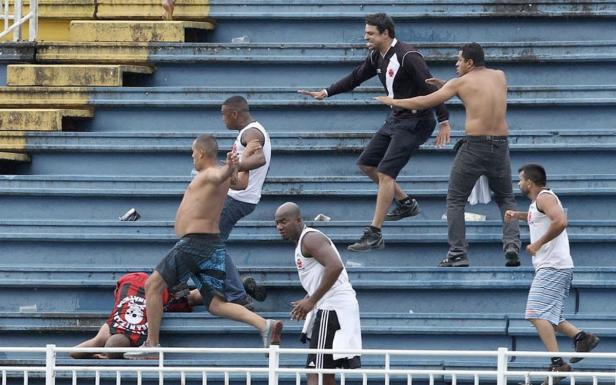 Mehrere Männer rennen und kämpfen auf den Stufen eines Stadions.