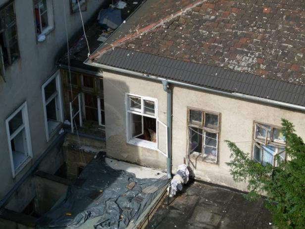 Blick von oben auf einen Hinterhof mit alten Häusern und Wäscheleine.