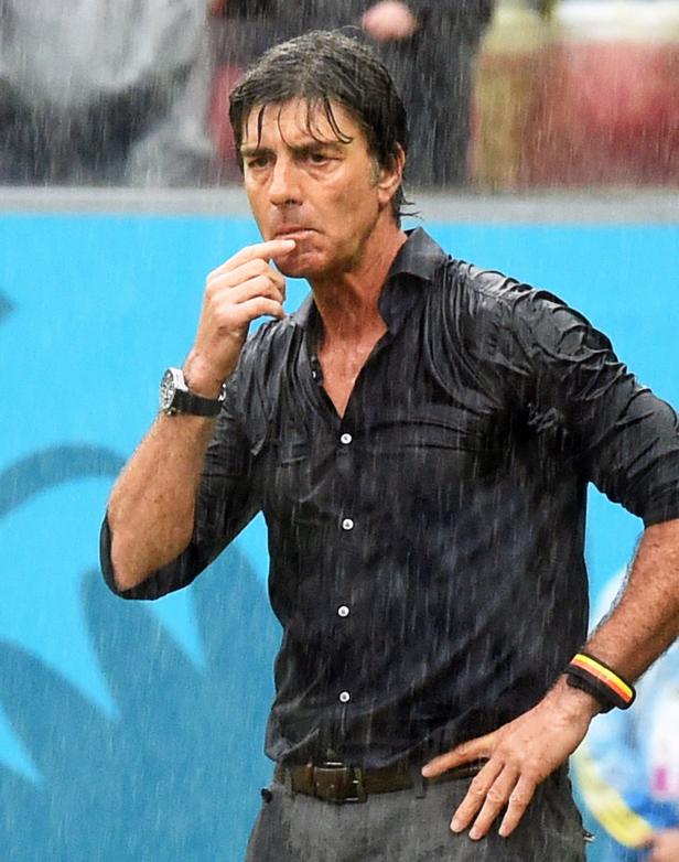 Joachim Löw steht im Regen und scheint nachzudenken.