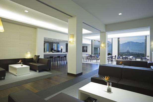 Ein moderner Hotellobby-Bereich mit Sitzgelegenheiten und Blick auf die Berge.