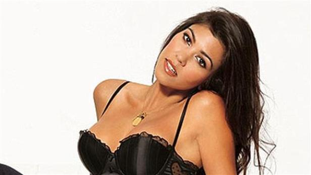 Kourtney Kardashian posiert in einem schwarzen Spitzen-BH und einer goldenen Halskette.