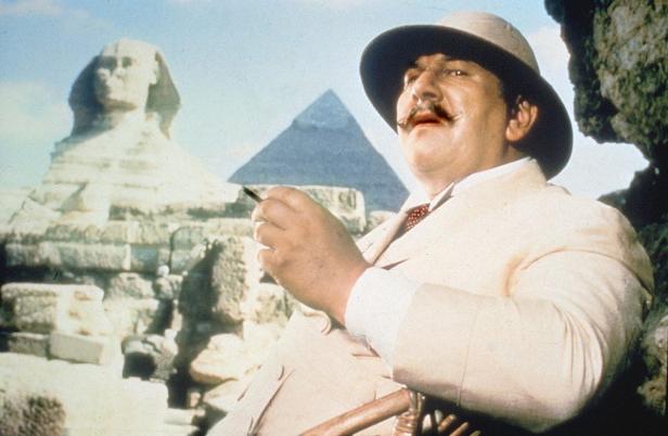Peter Ustinov als Detektiv Hercule Poirot vor der Sphinx und einer Pyramide in Ägypten.