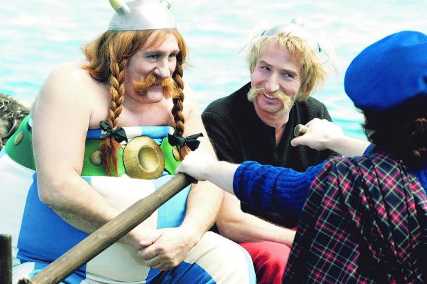 Asterix und Obelix in Kostümen sitzen in einem Boot.
