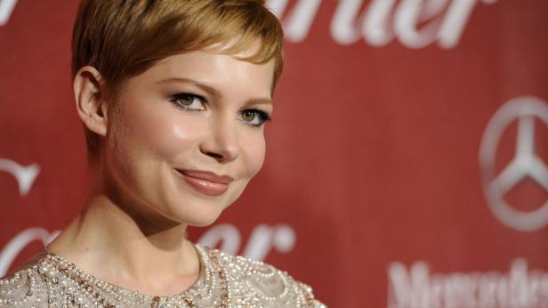 Michelle Williams lächelt auf einem roten Teppich.