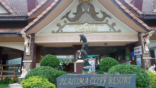 Das Plaloma Cliff Resort mit einer Skulptur von Delfinen vor dem Eingang.