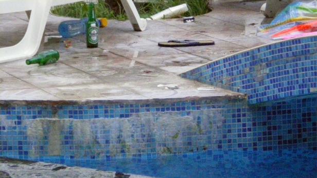 Am Pool liegen leere Flaschen und eine einzelne Sandale.