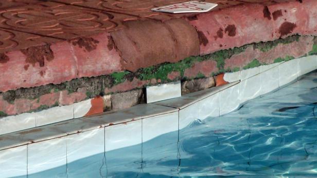 Detailaufnahme vom Beckenrand eines Schwimmbads mit Wasser und Fliesen.