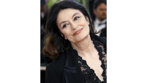 Schauspielerin Hanna Schygulla lächelt in einem schwarzen Spitzenoberteil.