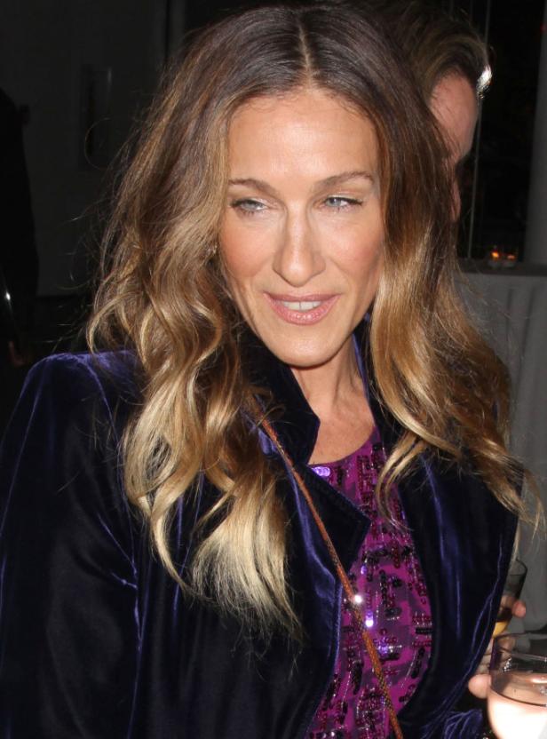 Sarah Jessica Parker trägt eine lila Samtjacke und ein glitzerndes Oberteil.