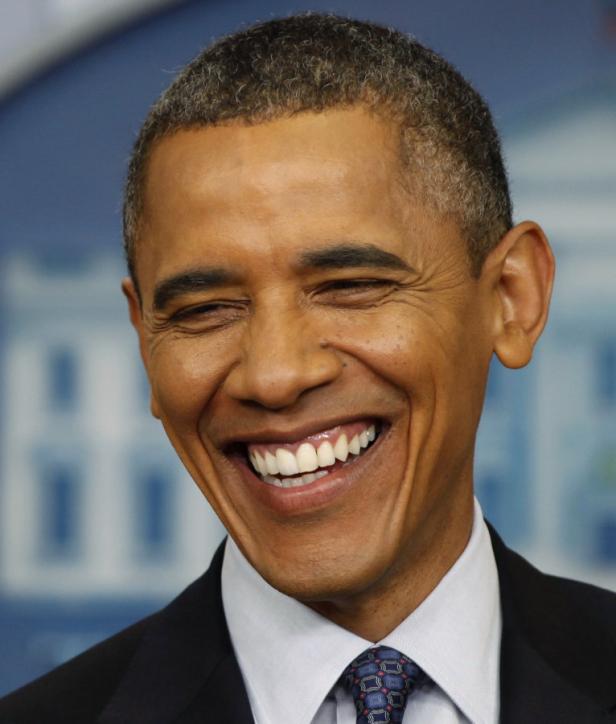 Ein lachender Barack Obama in Anzug und Krawatte.