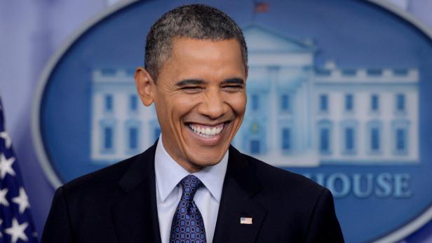 Ein lächelnder Barack Obama vor einem Hintergrund des Weißen Hauses.