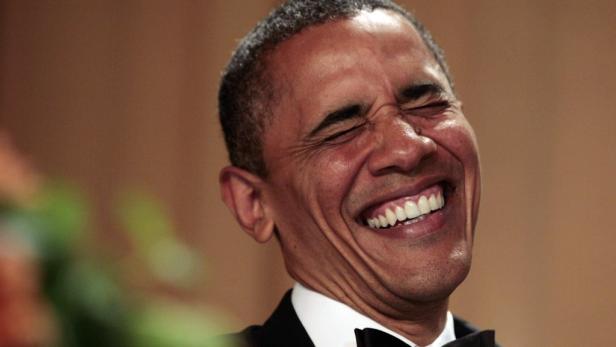 Ein lachender Barack Obama mit geschlossenen Augen und einem Smoking.