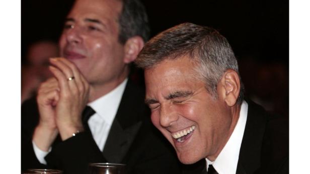 George Clooney lacht auf einer Veranstaltung.