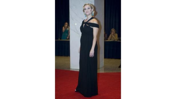 Reese Witherspoon in einem schwarzen Kleid auf einem roten Teppich.