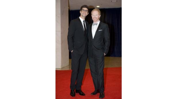 Jesse Tyler Ferguson und sein Ehemann Justin Mikita posieren auf einem roten Teppich.