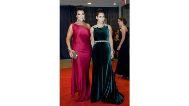 Kris Jenner und Kim Kardashian posieren auf einem roten Teppich.