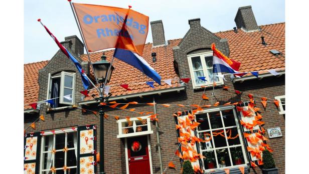 Ein mit niederländischen Flaggen und orangefarbenen Wimpeln geschmücktes Haus zum Koningsdag.