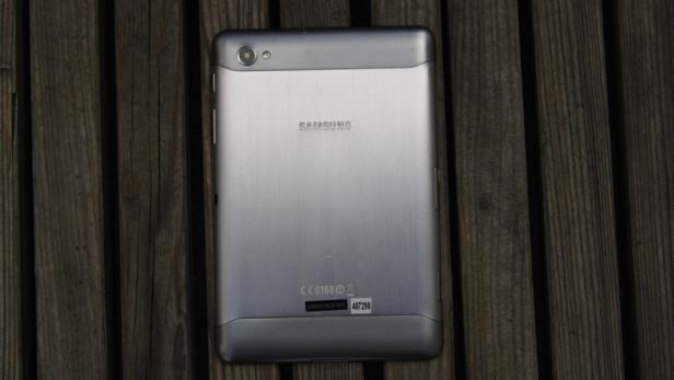 Die Rückseite eines silbernen Samsung Tablets liegt auf einem Holztisch.