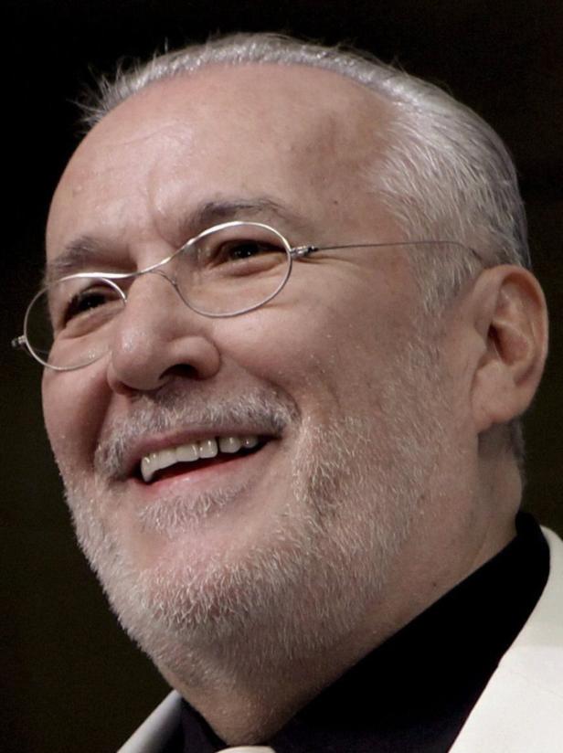 Ein Mann mit Brille und grauem Bart lächelt.