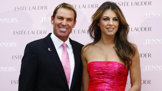 Shane Warne und Elizabeth Hurley posieren auf einer Veranstaltung von Estée Lauder.
