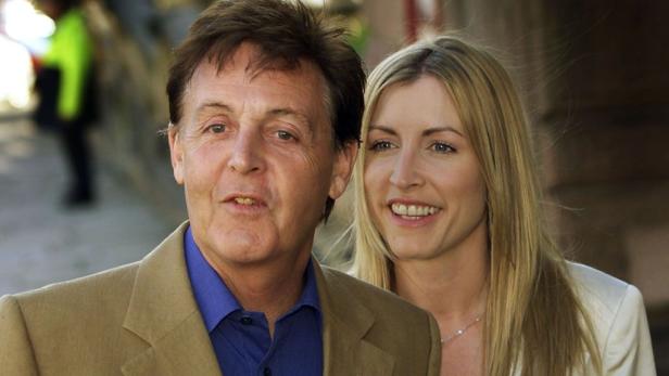 Paul McCartney mit einer blonden Frau, möglicherweise Heather Mills, lächeln in die Kamera.