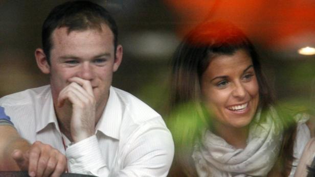 Wayne Rooney und Coleen Rooney schauen lächelnd zu.