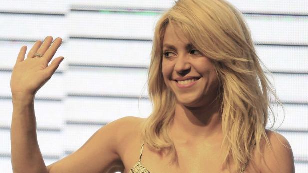 Shakira lächelt und winkt in die Kamera.