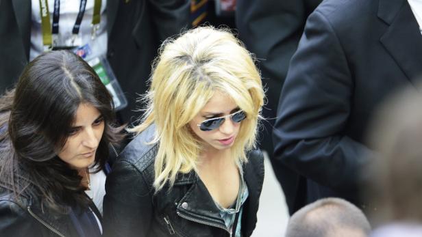 Shakira mit Sonnenbrille und Lederjacke, neben einer Frau mit dunklen Haaren.