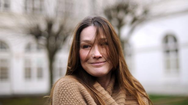 Eine Frau mit langen braunen Haaren lächelt in die Kamera.