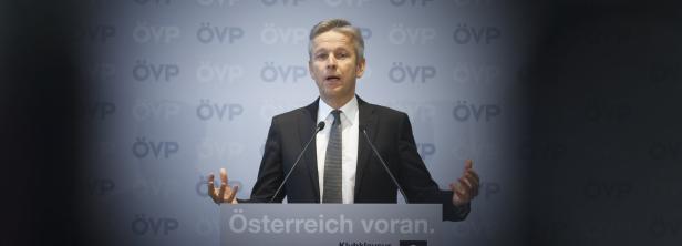 Ein Mann in einem Anzug spricht vor einem Hintergrund mit dem ÖVP-Logo.