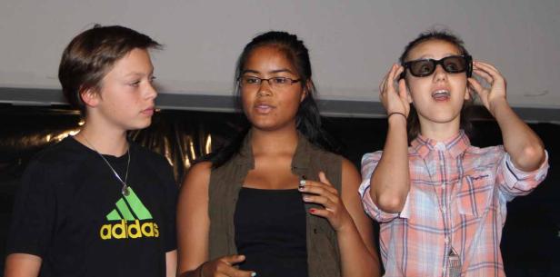 Drei Jugendliche, eine davon mit 3D-Brille, stehen nebeneinander.