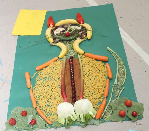 Ein Katzenbild, das aus verschiedenen Lebensmitteln wie Bananen, Karotten und Nudeln besteht.