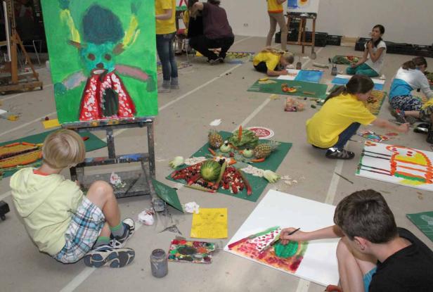 Kinder malen in einem Raum Stillleben mit Obst und Gemüse.