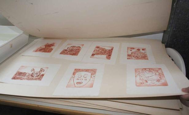 Eine Sammlung von Radierungen in einem geöffneten Portfolio.