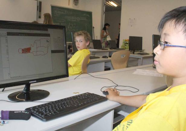 In einem Computerraum arbeiten zwei Jungen an Computern.