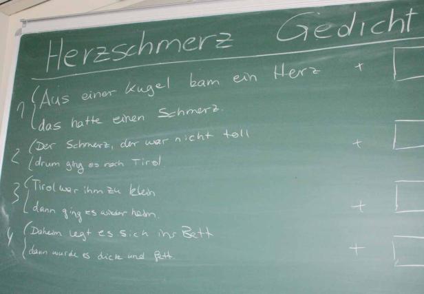Ein Gedicht über Herzschmerz ist auf eine grüne Tafel geschrieben.
